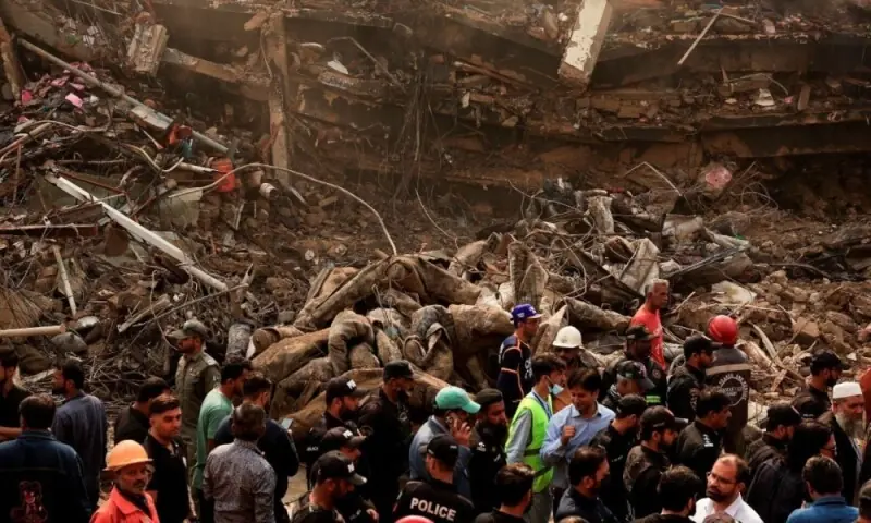 Police officers, rescue workers and shopkeepers gather, following a massive fire in the Gul Plaza shopping mall in Karachi, on January 19, 2026. Photo: Reuter