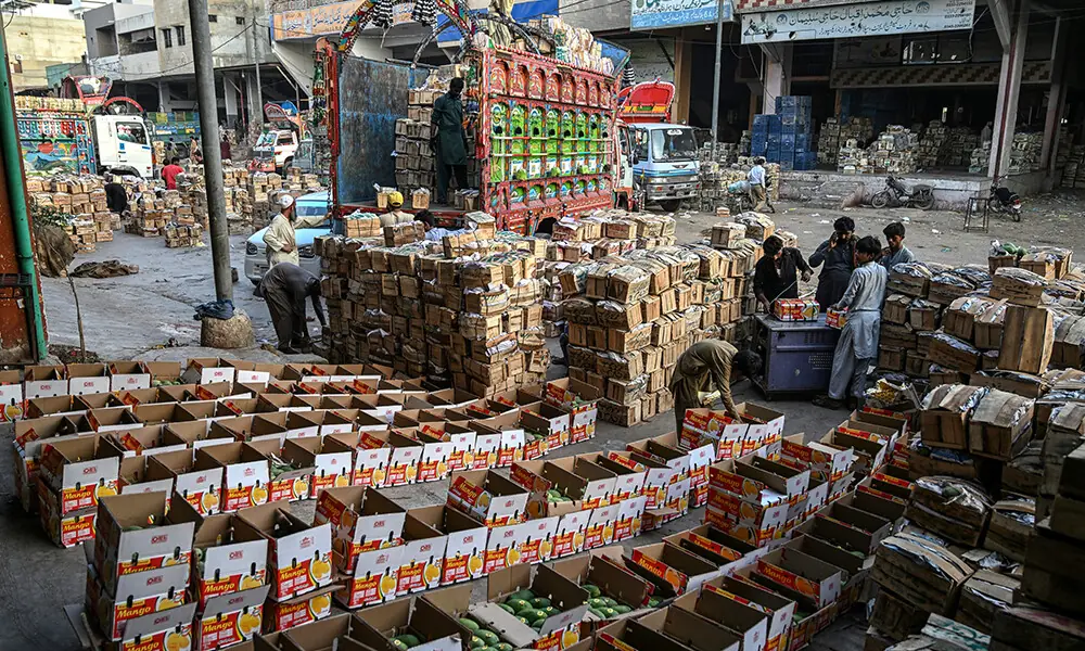 This photograph taken on June 5, 2026 shows workers loading boxes of mangoes onto a truck at a market in Karachi. Photo: AFP