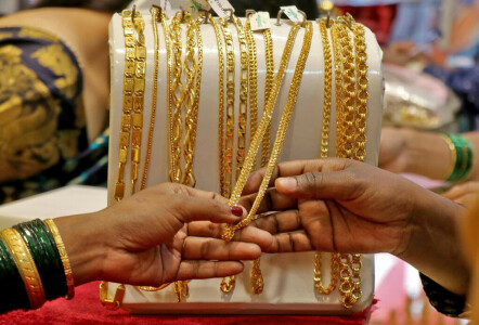 Gold falls 1% on surging dollar, hawkish Fed