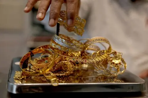 Gold dips on stronger dollar, US-China trade deal hopes