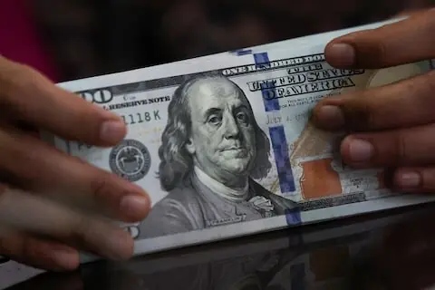 Dollar holds gains in thin trading as markets await Fed minutes, US GDP