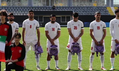 Iranian players hold schoolbags in protest over slain girls