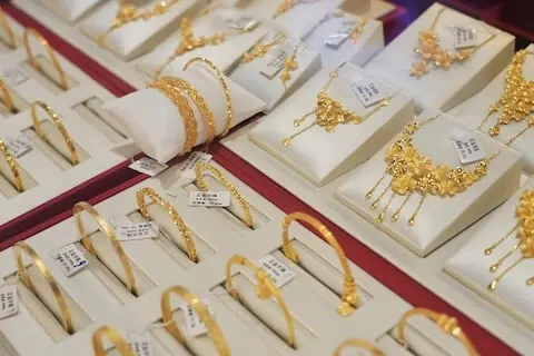 Gold inches lower as firmer dollar, higher yields weigh