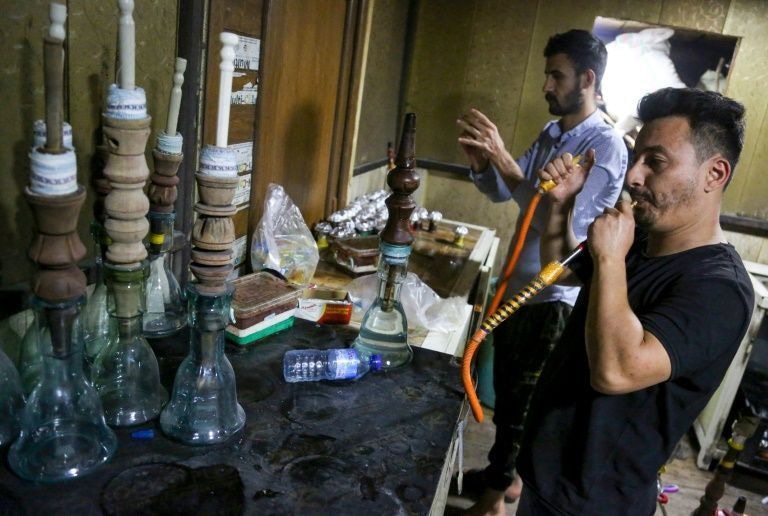 Employees prepare waterpipes for customers at a coffee shop in Karbala -- complete with the locally carved wooden section.