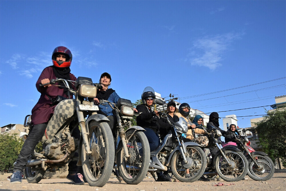  Members and students of the &lsquo;Rowdy Riders&rsquo; line up before taking their bikes onto an open ground in Karachi. Photo: AFP 