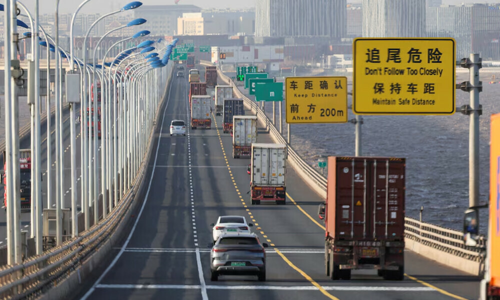 Trucks loaded with shipping containers pass over Donghai Bridge to exit Yangshan Port outside of Shanghai, China. Photo: Reuters