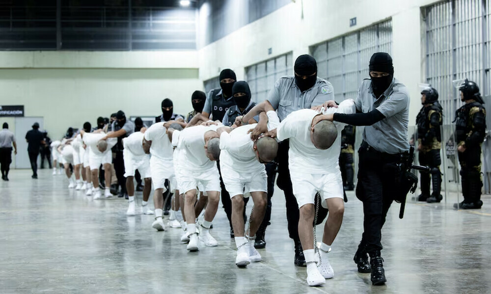 Salvadoran police officers escort alleged members of the Venezuelan gang Tren de Aragua recently deported by the U.S. government to be imprisoned in the Terrorism Confinement Center (CECOT) prison, as part of an agreement with the Salvadoran government, in Tecoluca, El Salvador, in this handout image obtained March 16, 2025. Secretaria de Prensa de la Presidencia/Handout via REUTERS
