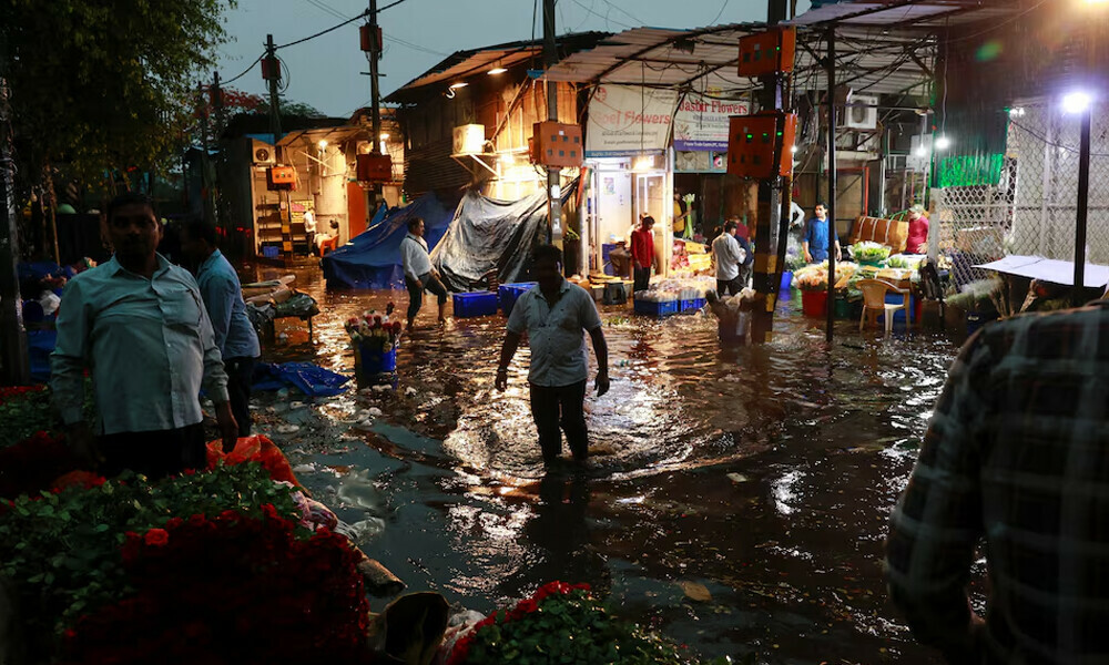 A man wades through a waterlogged street in a wholesale market after rain, in New Delhi, India May 2, 2025. REUTERS