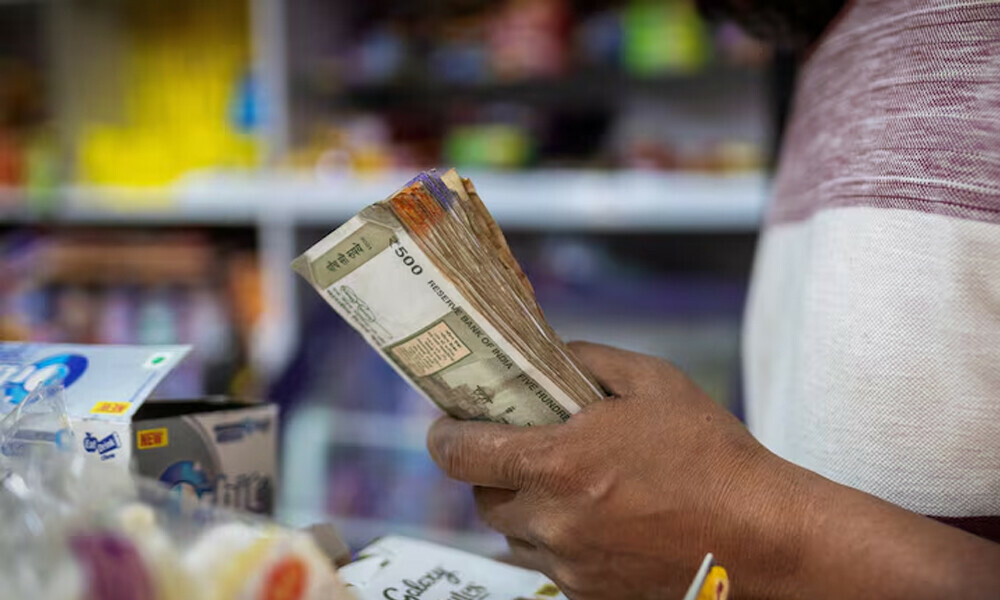 A man holds Indian currency notes inside a shop in New Delhi, India, April 3, 2025. REUTERS