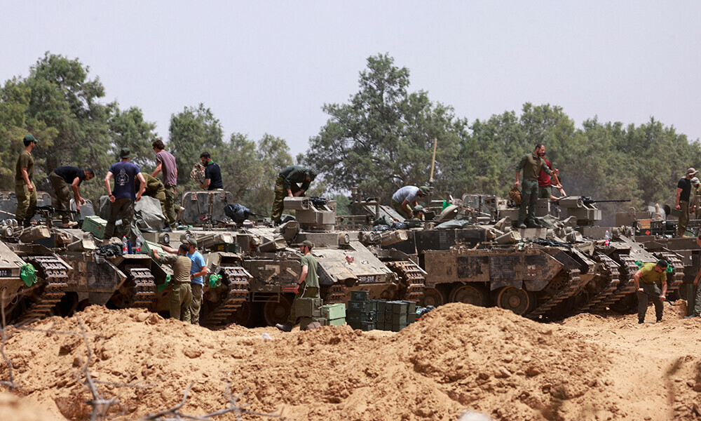 Israeli troops work on their armoured vehicles at a position by Israel’s border with the Gaza Strip on May 18, 2025. Photo: AFP