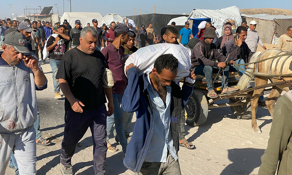 Displaced Palestinians carrying bags of relief supplies return from aid distribution centres in Rafah to their tents in the southern Gaza Strip on May 29, 2025. Photo: AFP