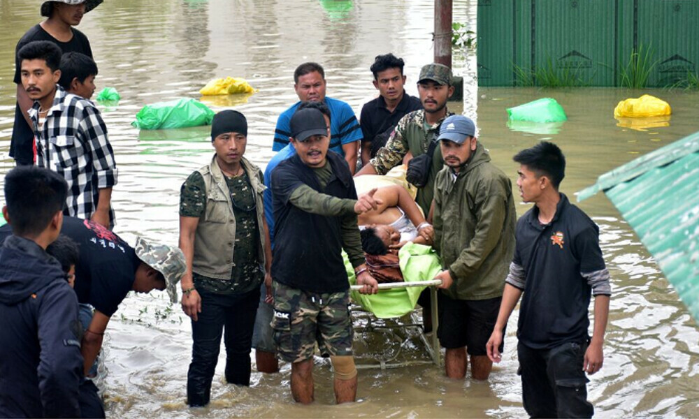 People carry a patient on a stretcher as they wait for a rescue boat to evacuate him from the flood-affected Jawaharlal Nehru Institute of Medical Sciences hospital, following heavy rains in Imphal East, Manipur, India June 1, 2025. Photo: Reuters