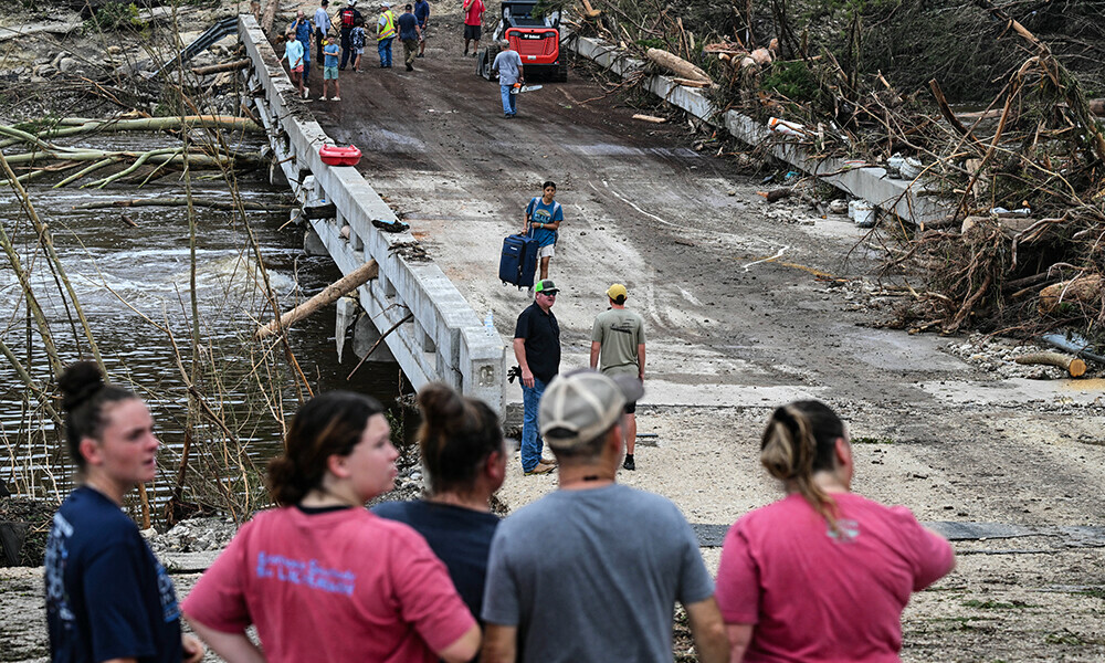 People look on as law enforcement and volunteers continue to search for missing people near Camp Mystic, the site of where at least 20 girls went missing after flash flooding in Hunt, Texas, on July 5, 2025. Photo: AFP