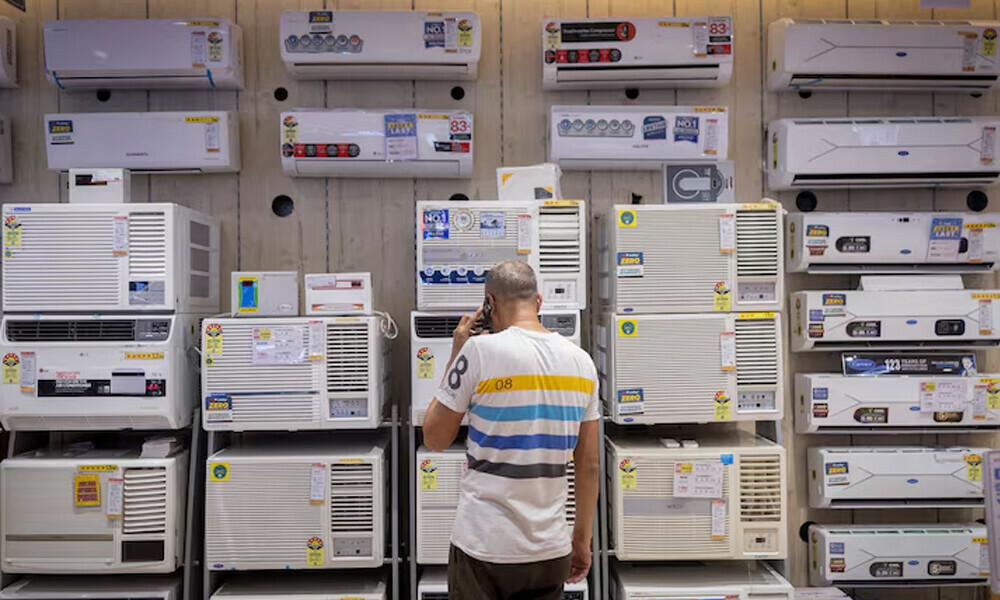 A man looks at air conditioners displayed inside an electronics store, on a hot summer day in New Delhi, India, April 9, 2025. REUTERS