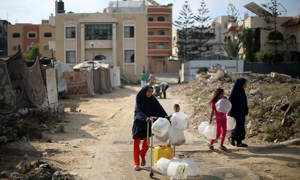 Displaced Palestinians carry empty containers on their way to fetch water at a distribution point in the Nuseirat refugee camp in the central Gaza Strip on July 10, 2025. Photo: AFP