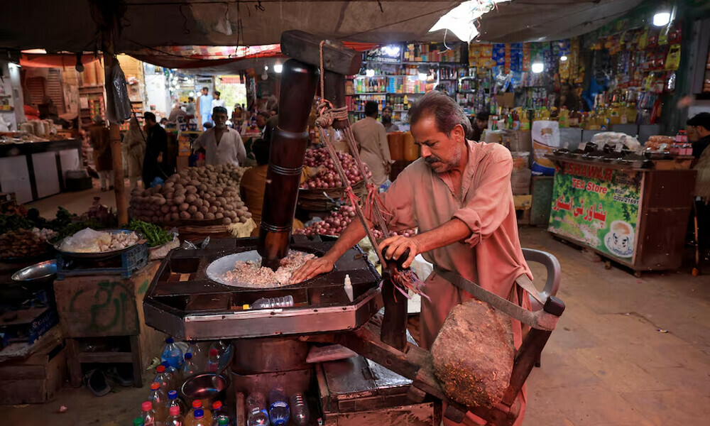 A worker uses a traditional wooden extractor to extract almond oil at the Empress Market, built in the British colonial period. Photo: Reuters 