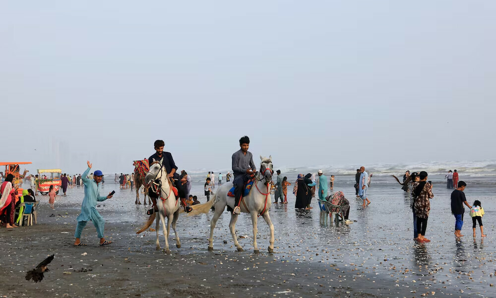  Beachgoers ride horses at Clifton Beach. Photo: Reuters 