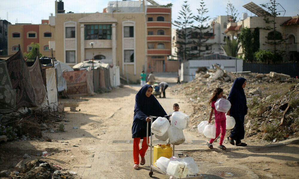 Displaced Palestinians carry empty containers on their way to fetch water at a distribution point in the Nuseirat refugee camp in the central Gaza Strip on July 10, 2025. Photo: AFP