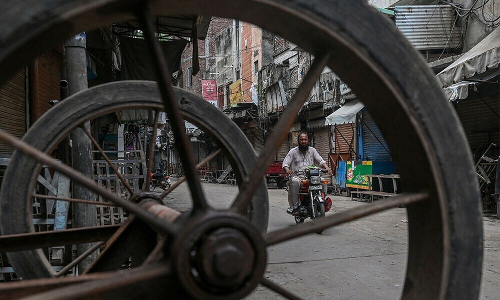 A motorcyclist rides through a partially deserted street during a nationwide strike called by traders against the government’s new tax policies at a closed market in Lahore on July 19, 2025. Photo: AFP