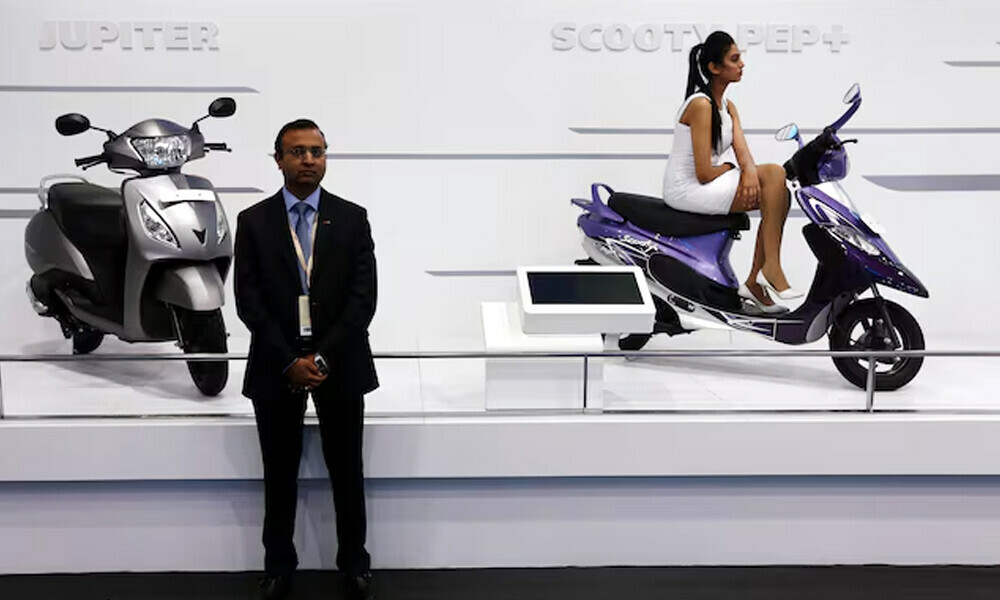 A model sits on a scooter at the TVS Motor company&rsquo;s pavilion. Photo: Reuters