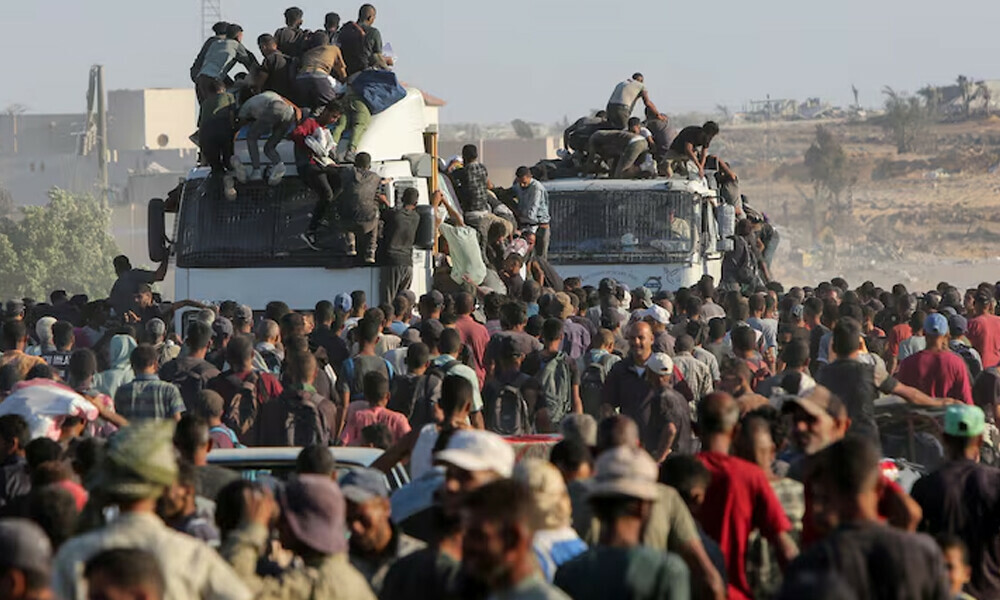 Palestinians climb onto trucks as they seek aid supplies in Khan Younis, southern Gaza Strip, August 4, 2025. REUTERS