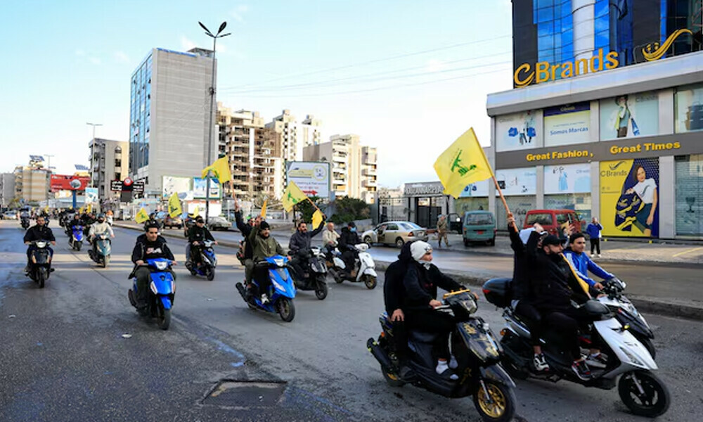 Men carry Hezbollah flags while riding on two wheelers, at the entrance of Beirut&rsquo;s southern suburbs, in Lebanon, November 27, 2024. REUTERS