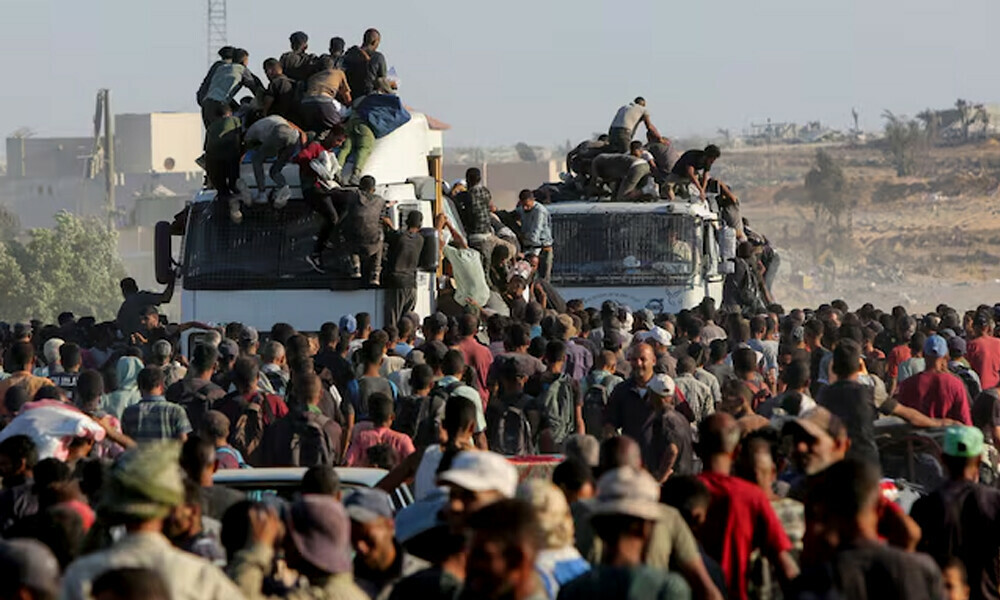Palestinians climb onto trucks as they seek aid supplies in Khan Younis, southern Gaza Strip, August 4, 2025. REUTERS