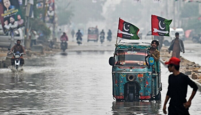 An auto rickshaw makes its way through a flooded artery in Karachi on February 4, 2024. Photo: AFP