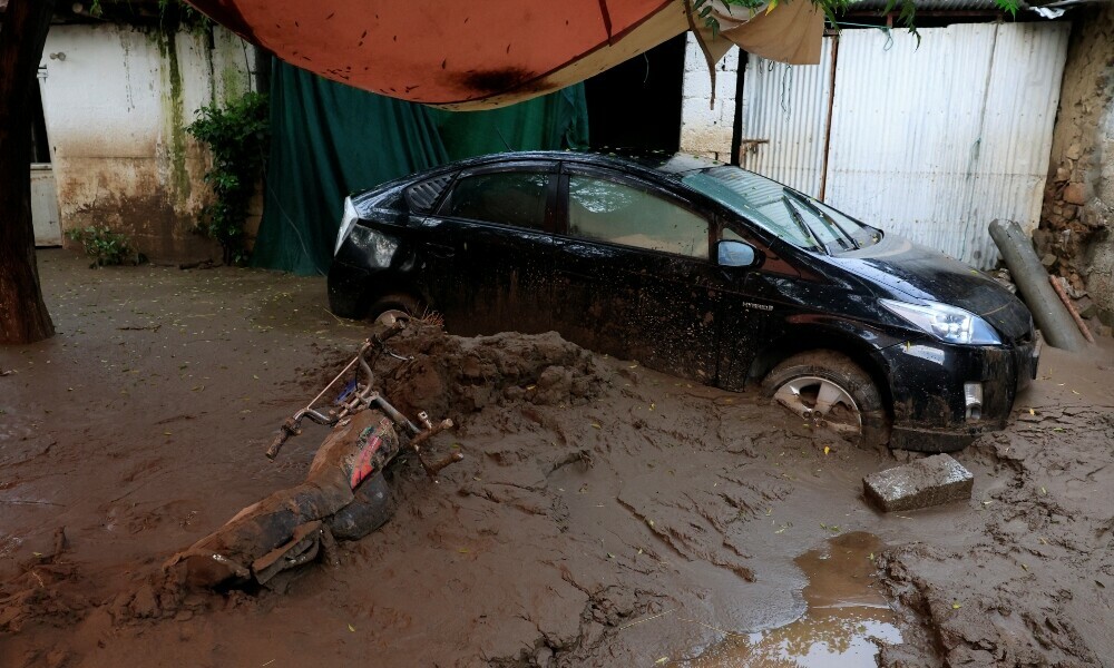 A motorcycle lies partially covered by a thick layer of mud next to a stranded vehicle, following a storm that caused heavy rains and flooding in Pacha Kalay Bazar, in Buner district of Khyber Pakhtunkhwa, on August 17, 2025. Photo: Reuters