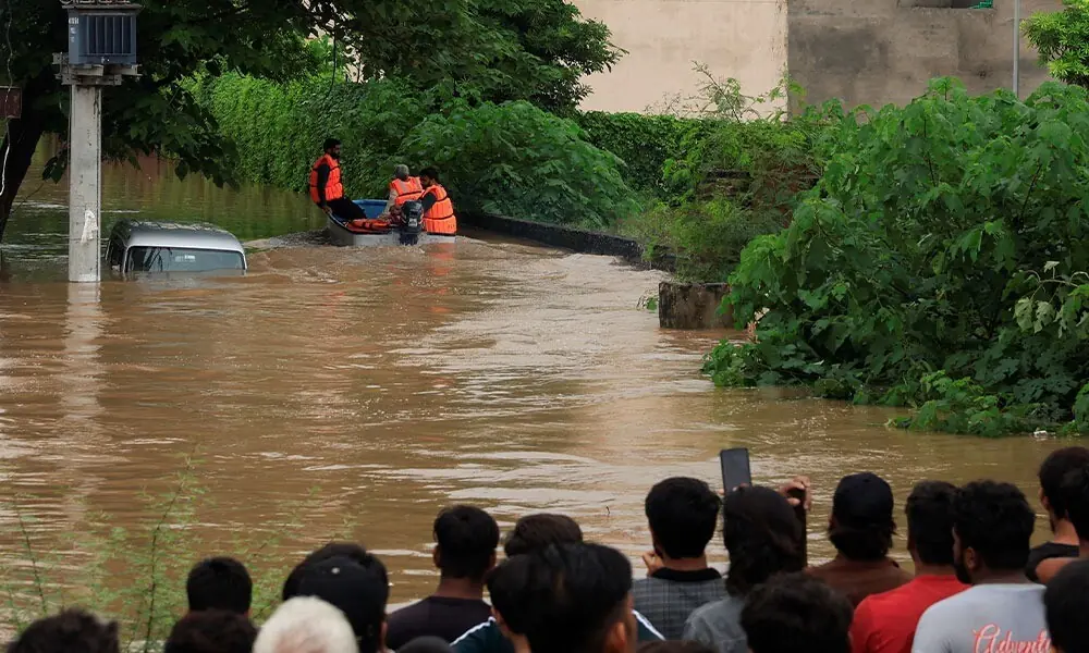  Volunteers from Rescue 1122 search for residents in a flooded area, following monsoon rains and rising water levels in Sialkot, Punjab province, Pakistan, August 27, 2025. REUTERS/Akhtar Soomro 