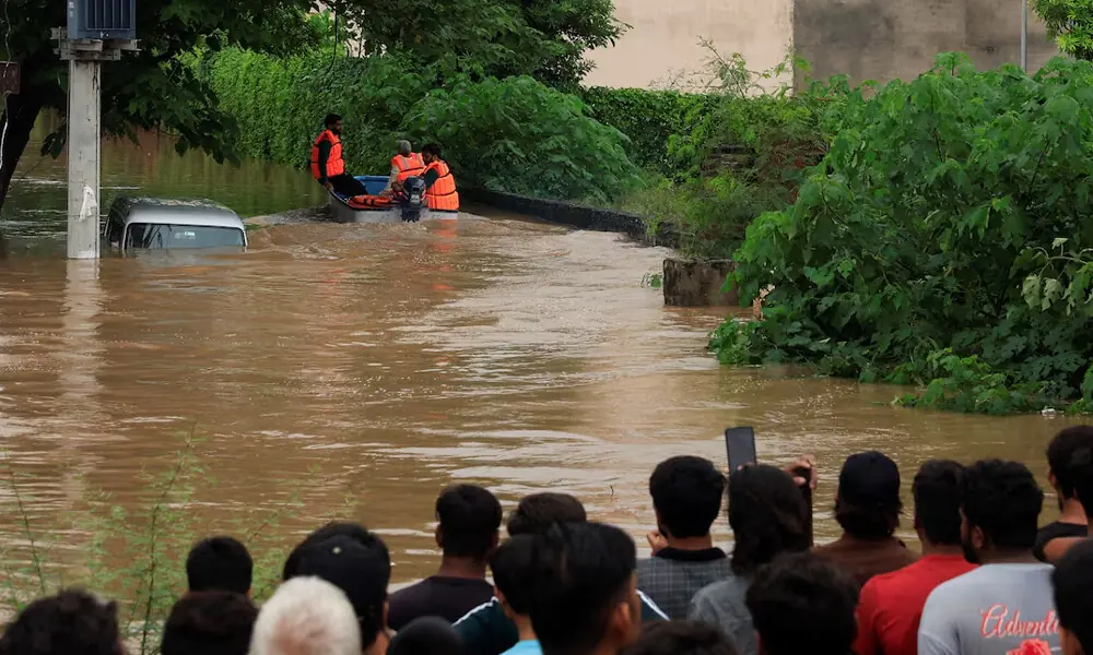 Volunteers from Rescue 1122 search for residents in a flooded area, following monsoon rains and rising water levels in Sialkot, Punjab province, Pakistan, August 27, 2025. REUTERS