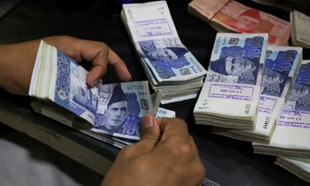 An employee counts Pakistani rupee notes at a bank in Peshawar. Photo: Reuters/File