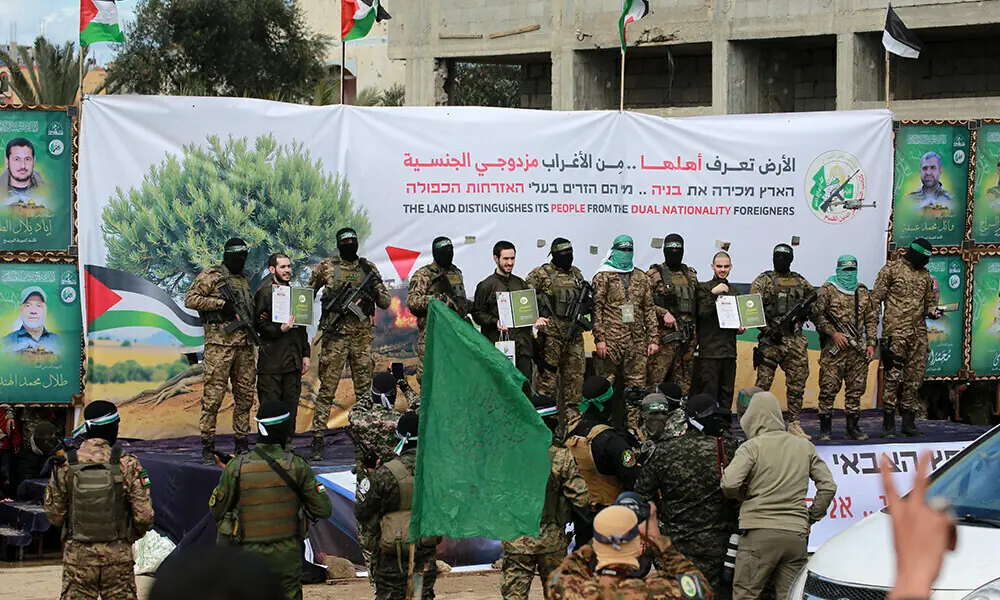 Hamas fighters parade newly-released Israeli hostages (L to R) Elia Cohen, Omer Shem Tov and Omer Wankert on stage in Nuseirat in the central Gaza Strip, as part of the seventh hostage-prisoner release on February 22, 2025. File Photo: AFP