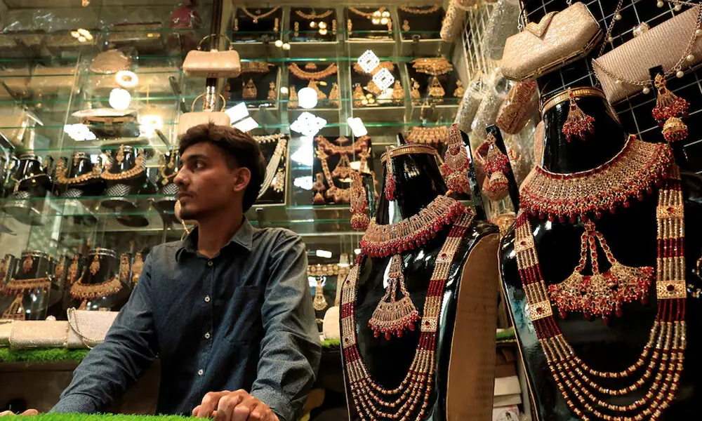 A shopkeeper waits for customers while selling locally made jewellery at a market in Karachi, Pakistan. Photo: Reuters
