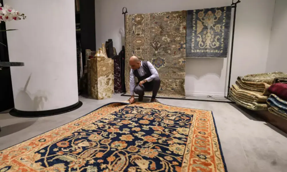 A man inspects a handmade rug in a carpet shop in northern Tehran. Photo: AFP
