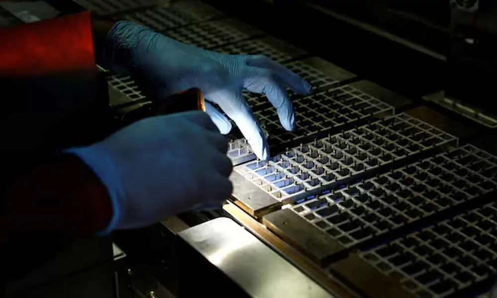 A technician checks the machine with a flashlight at a solar panel manufacturing hub in Greater Noida, on the outskirts of New Delhi India. Photo: Reuters A technician checks the machine with a flashlight at a solar panel manufacturing hub in Greater Noida, on the outskirts of New Delhi India. Photo: Reuters