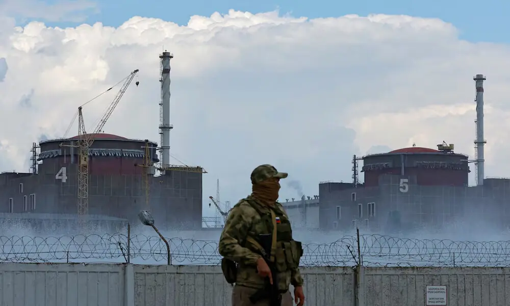 A serviceman with a Russian flag on his uniform stands guard near the Zaporizhzhia Nuclear Power Plant in the course of Ukraine-Russia conflict outside the Russian-controlled city of Enerhodar in the Zaporizhzhia region, Ukraine August 4, 2022. REUTERS