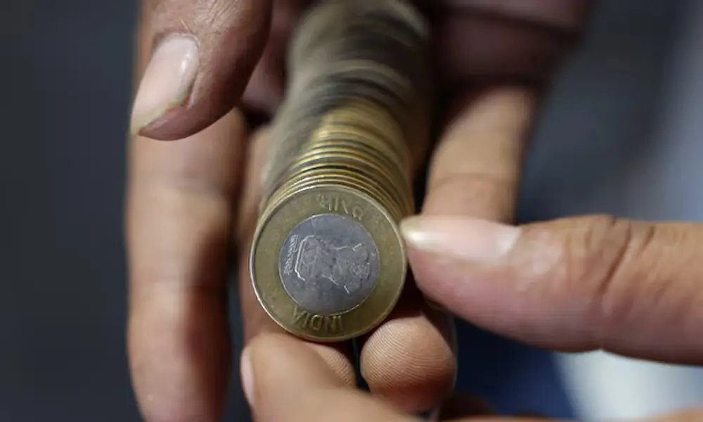 A shopkeeper counts Indian currency coins at his shop, in the old quarters of Delhi, India, September 24, 2025. REUTERS