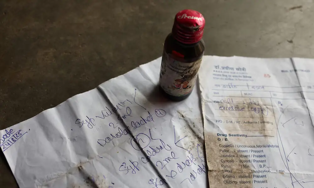 A bottle of Coldrif cough syrup and a prescription which Reema Yaduvanshi, 26, received from doctor Praveen Soni for her six-month-old son Kartik, in Parasia, Madhya Pradesh, India, October 10, 2025. The syrup was later banned, after it was linked to the deaths of multiple children, and is being recovered by community healthcare workers amid a door-to-door campaign to spread awareness and recall it. REUTERS