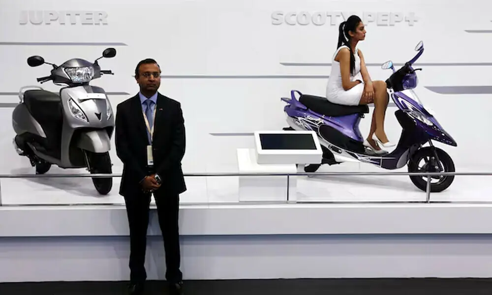A model sits on a scooter at the TVS Motor company&rsquo;s pavilion. Photo: Reuters