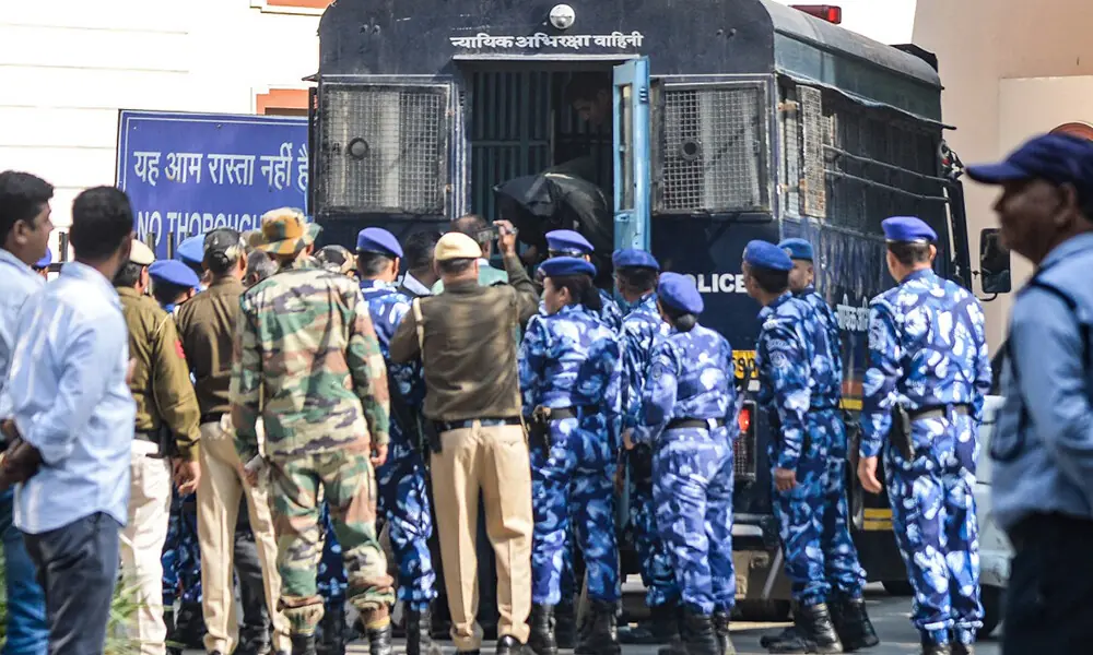 Security personnel escort alleged car blast accused Amir Rashid Ali (C top) from a police vehicle, with his face covered in black cloth at the Patiala House Court, a day after he was detained in New Delhi on November 17, 2025. Photo: AFP