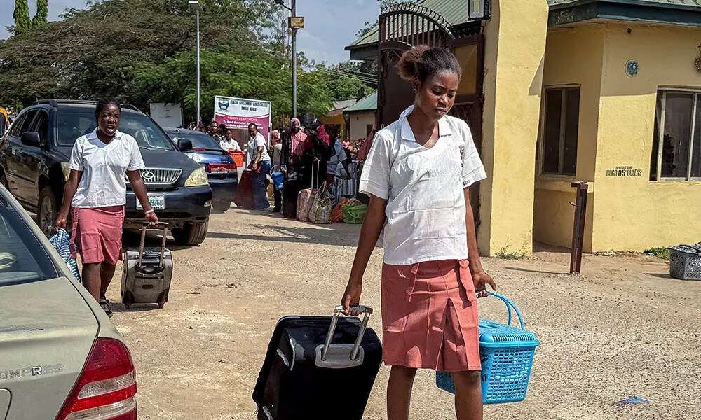 A student pulls her suitcase as she walks out of the Federal Government Girls College in Bwari, on the outskirts of Abuja, on November 22, 2025. Photo: AFP