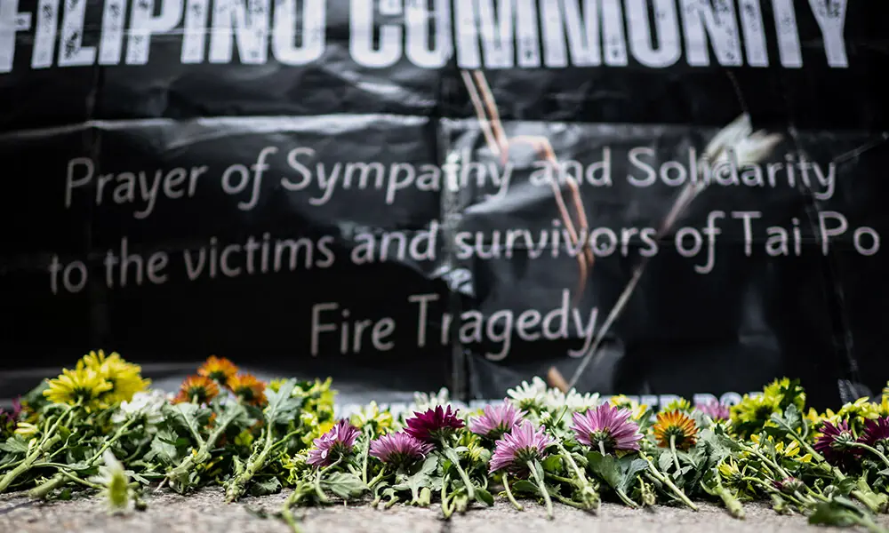 Flowers are placed for victims of the deadly November 26 fire as Philippine nationals in Hong Kong take part in a community prayer service at Tai Po, in Hong Kong&rsquo;s Central district on November 30, 2025. Photo: AFP