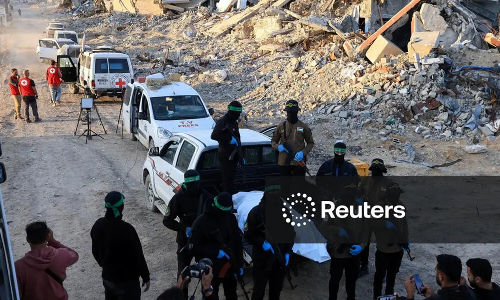 Palestinian Hamas and Islamic Jihad wait for Red Cross members to receive a body recovered by them, before it is handed over to Israel to determine whether it belongs to a hostage, in Beit Lahiya, in the northern Gaza Strip, December 3, 2025. REUTERS