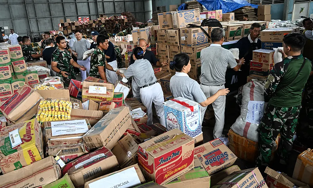 Soldiers and volunteers sort relief supplies inside a warehouse to be delivered to flood-affected areas in North Sumatra and Aceh, at Soewondo Air Base in Medan, North Sumatra, on December 12, 2025. Photo: AFP