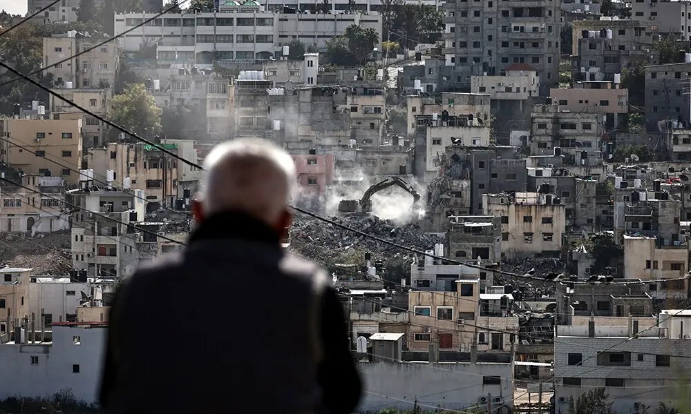 Residents of the Nur Shams Palestinian refugee camp watch their homes being demolished on New Year&rsquo;s eve by an Israeli military excavator in the Nur Shams camp, east of the northern Israeli-occupied West Bank city of Tulkarem, amid an ongoing offensives in the occupied-West Bank on December 31, 2025. Photo: AFP