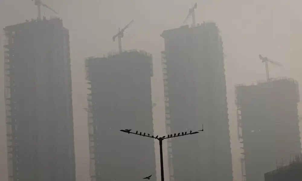 Residential buildings under construction are seen shrouded in heavy smog and air pollution in Noida, on the outskirts of New Delhi, India, December 19, 2025. REUTERS