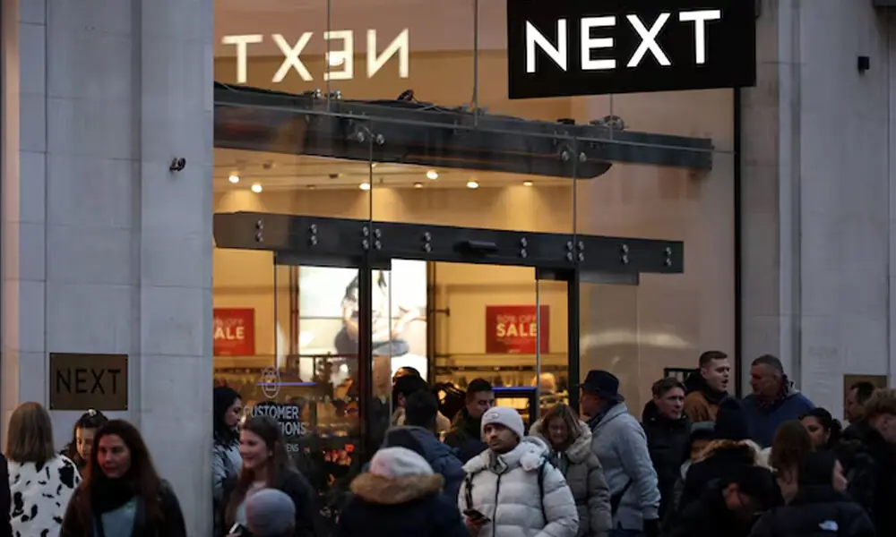 Shoppers walk past a NEXT retail store on Oxford Street in London, Britain, December 28, 2025. REUTERS