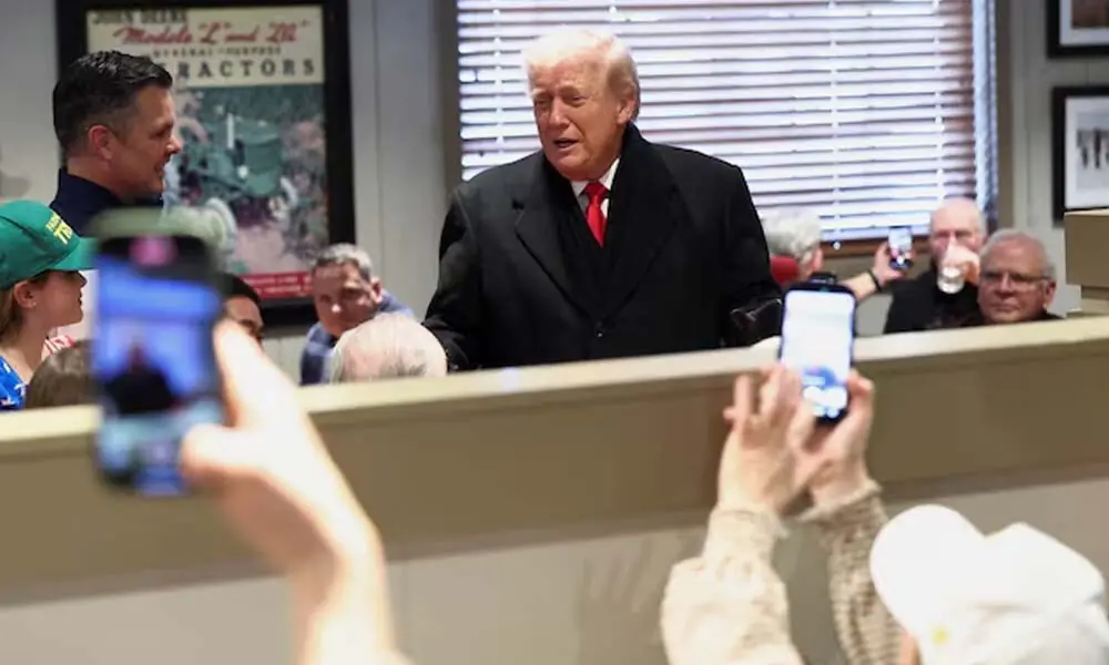People hold their phones up as U.S. President Donald Trump interacts with diners, in Machine Shed restaurant in Urbandale, Iowa, U.S. Reuters