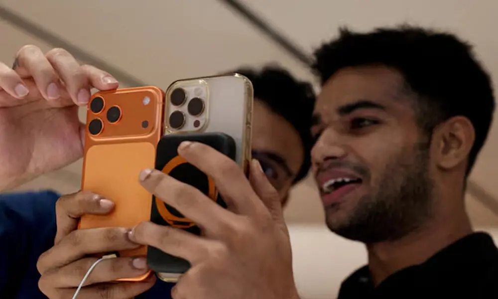 A customer compares his old iPhone with the newly launched iPhone 17 pro max at an Apple retail store in Delhi, India, September 19, 2025. File Photo: Reuters